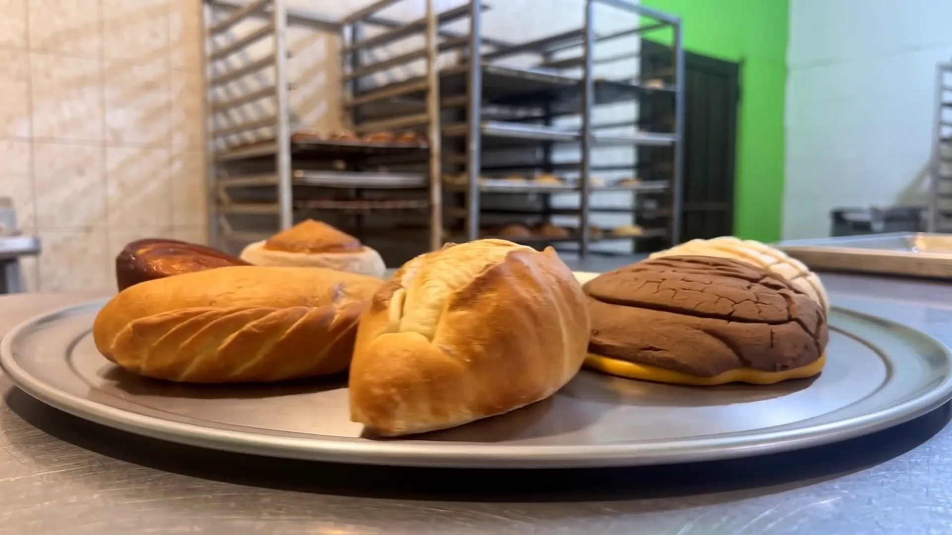 Charola de acero con pan dulce en el interior de la panadería.